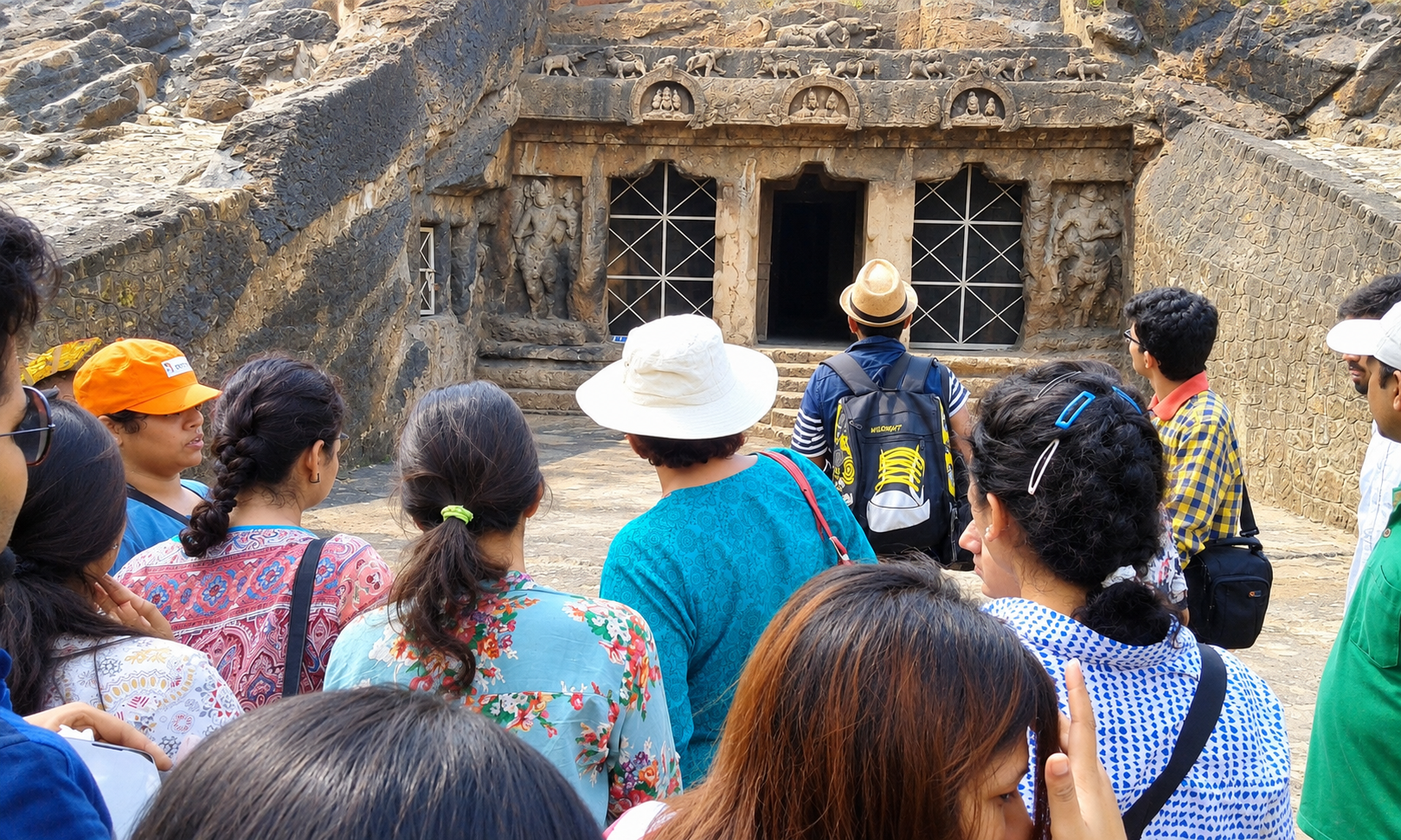 Students at the entrance of a rock-cut cave temple