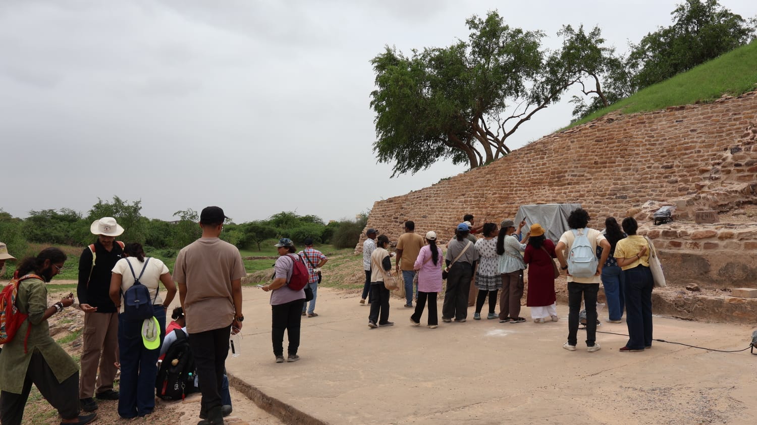 Students studying excavated stone walls at a Harappan archaeological site