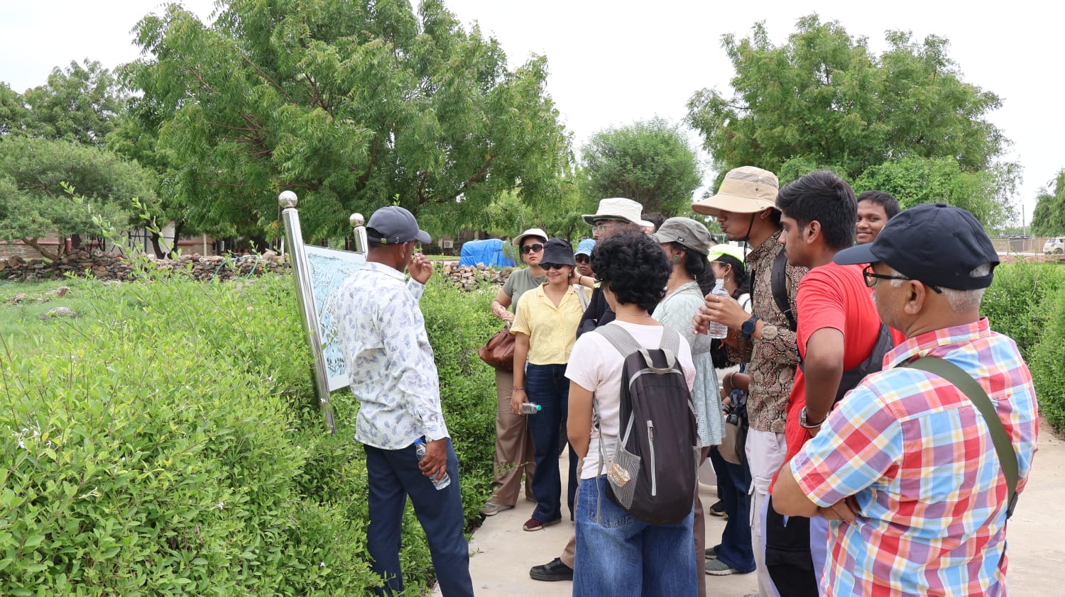 Students gathered around a site map with a local guide