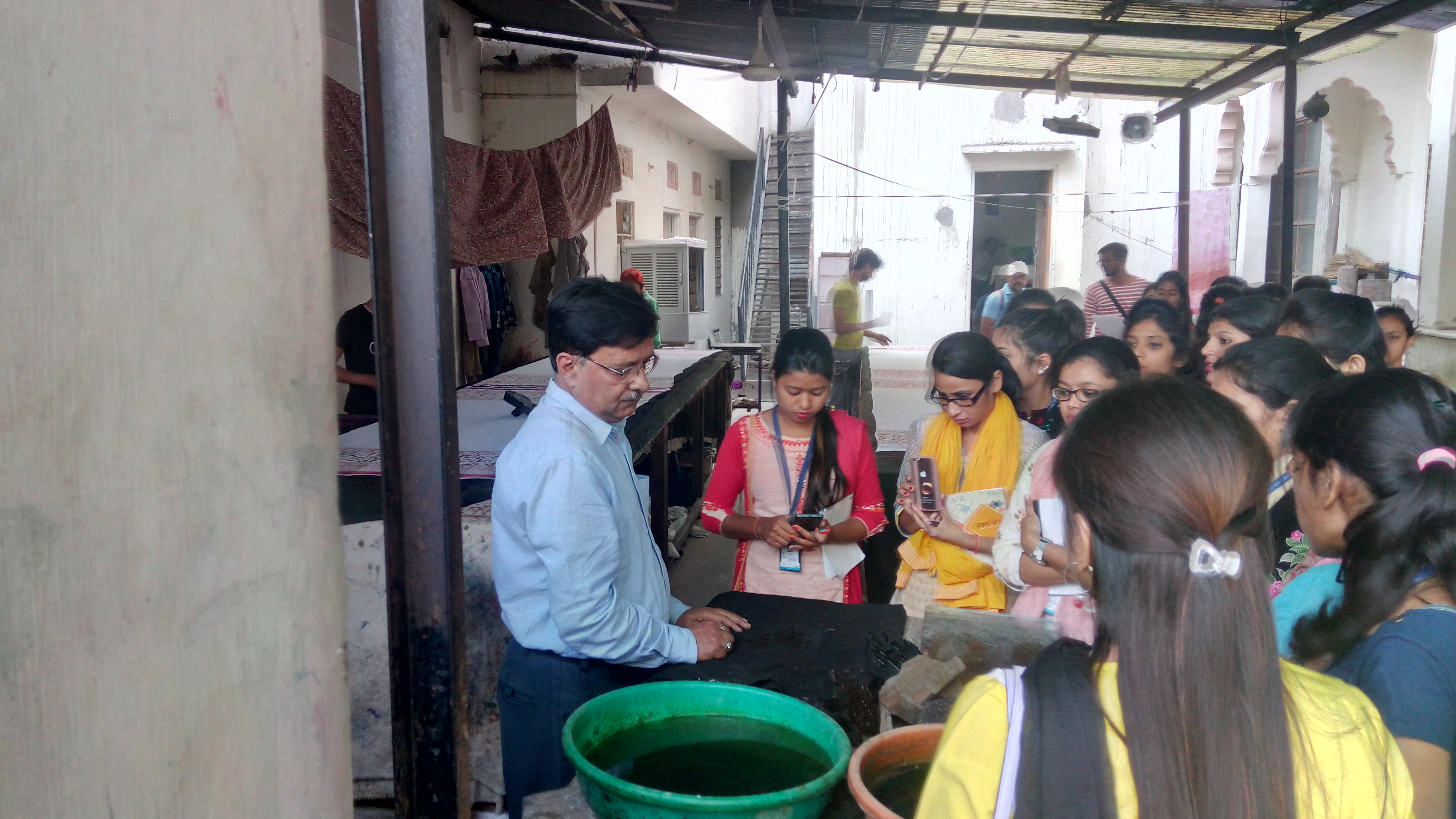 A facilitator explaining textile dyeing to students