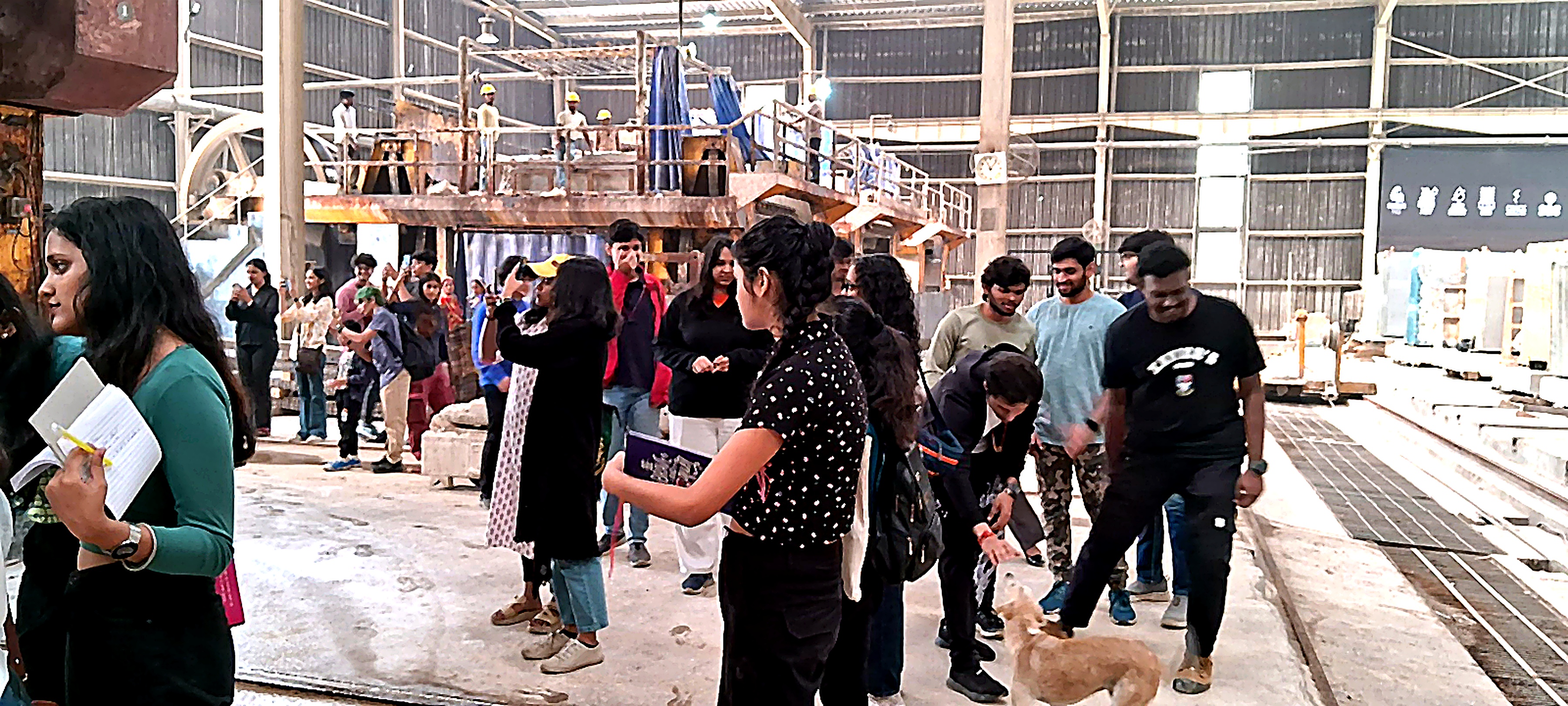 Students on a factory floor during an industry and technology programme