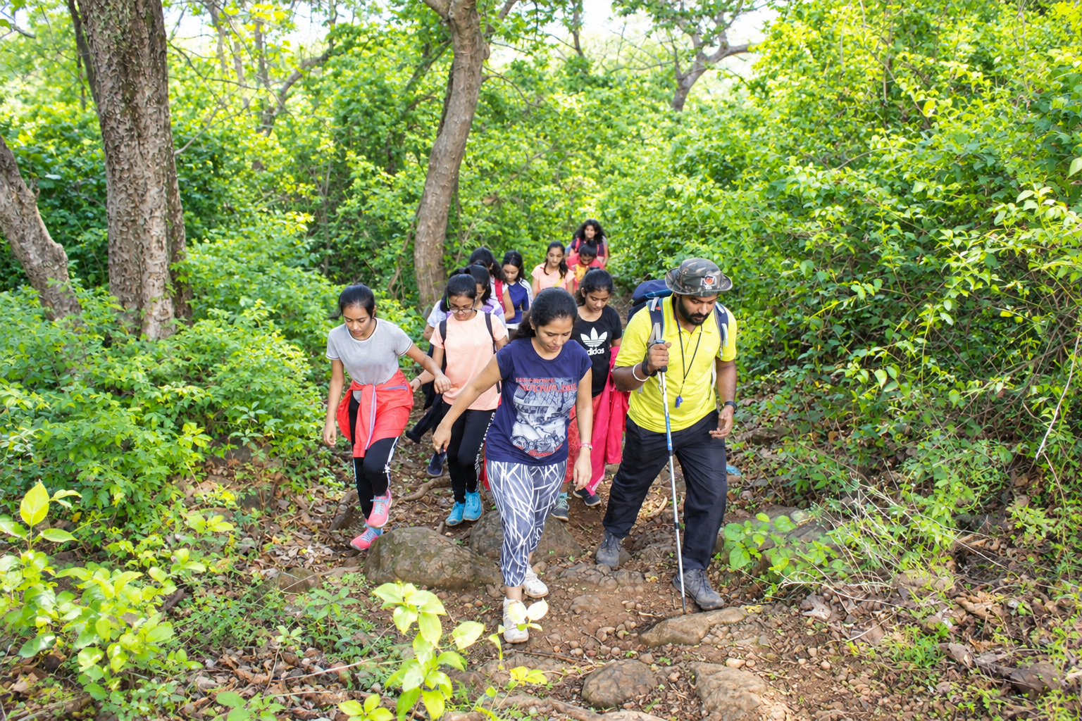 Students and a guide trekking through forest on an outbound programme