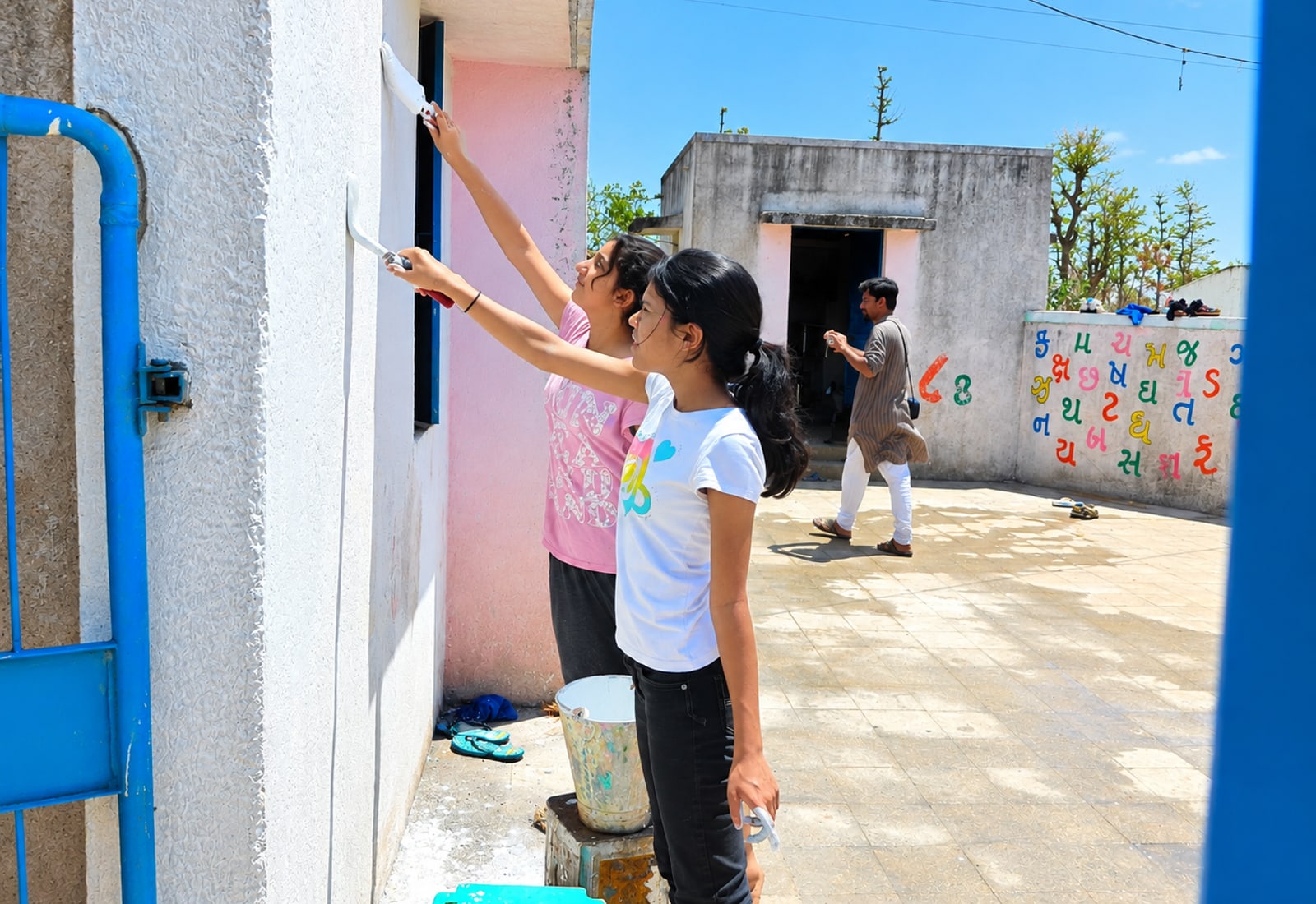 Students painting a village school building