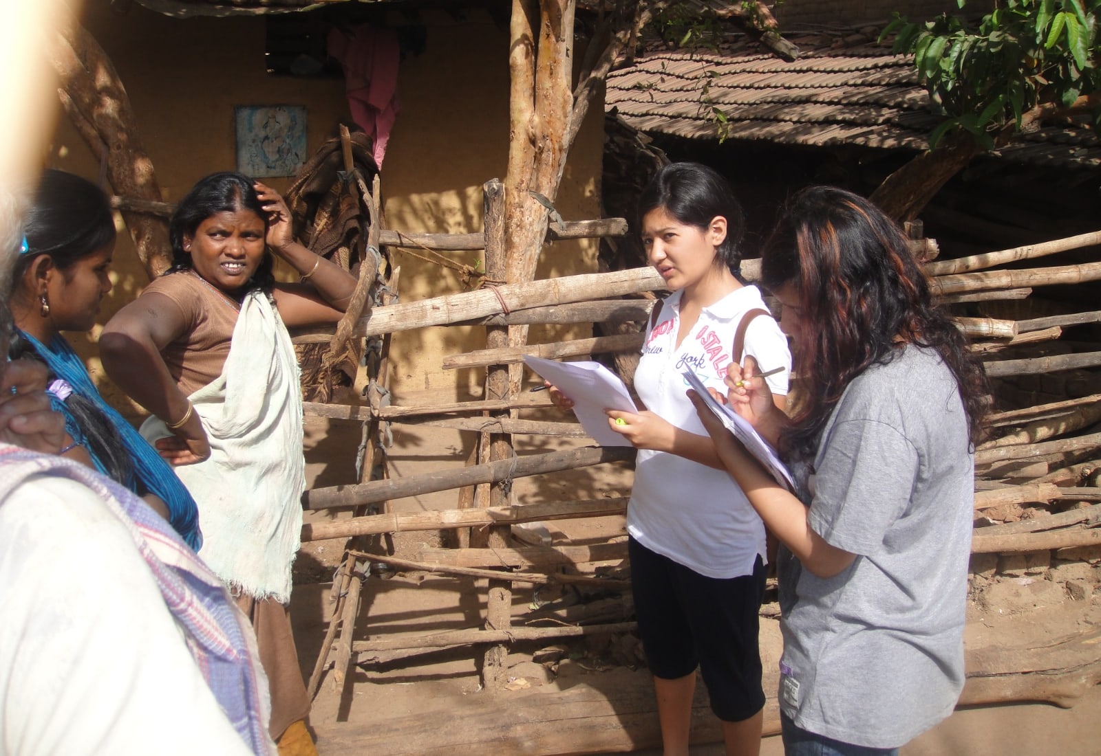 Students speaking with village residents during a community survey